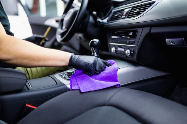 an e-hailing driver cleans his car interior before taking passengers