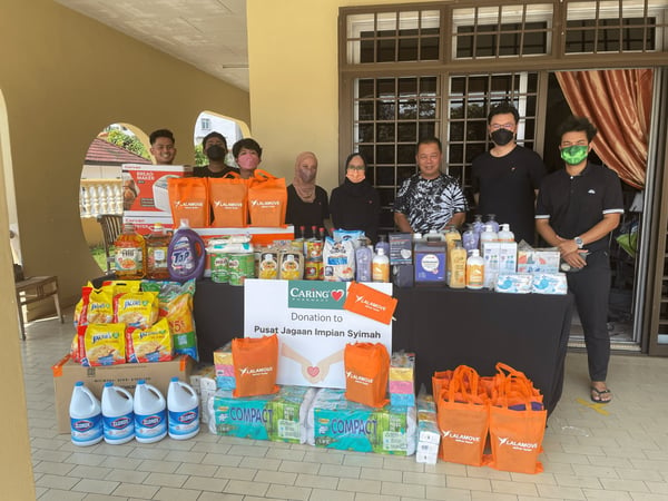 lalamove team in johor bahru takes photos with the donations of essential items at pusat impian syimah old folks home