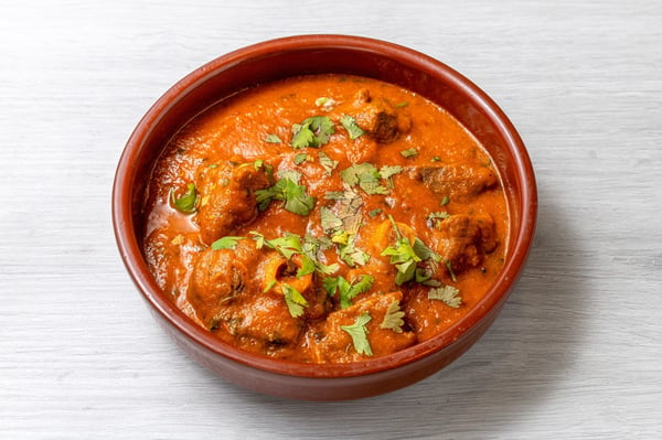 mutton curry in a brown bowl